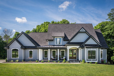 Imagen de fachada de casa azul tradicional renovada grande de dos plantas con revestimientos combinados y tejado de teja de madera