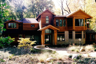Foto de fachada de casa marrón y gris rústica grande de dos plantas con revestimiento de madera, tejado a dos aguas y tejado de teja de madera