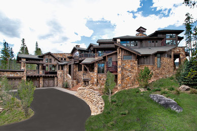 This is an example of a large contemporary house exterior in Denver with stone cladding and three floors.