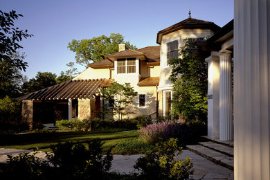Ejemplo de fachada beige tradicional extra grande de dos plantas con revestimiento de madera y tejado a cuatro aguas