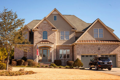 Diseño de fachada de casa multicolor clásica grande de dos plantas con revestimiento de ladrillo y tejado de teja de madera