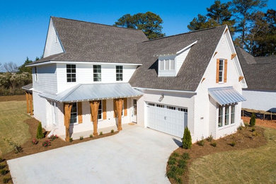 Example of a large cottage white two-story brick house exterior design in Atlanta with a hip roof and a shingle roof