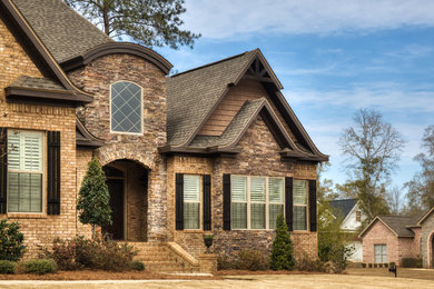 Example of a classic brown two-story brick exterior home design in Other