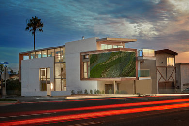 Großes, Dreistöckiges Modernes Haus mit Betonfassade, weißer Fassadenfarbe und Pultdach in Los Angeles