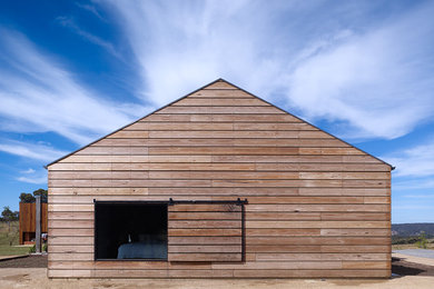 На фото: одноэтажный, деревянный, черный дом среднего размера в современном стиле с односкатной крышей