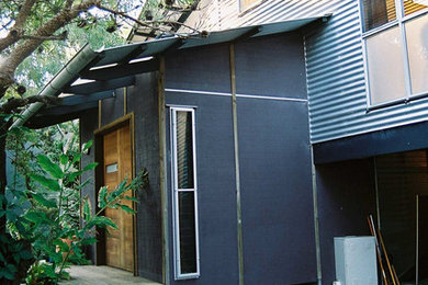 Ejemplo de fachada gris marinera de tamaño medio con revestimiento de metal y tejado de un solo tendido