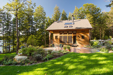 Modelo de fachada de casa marrón rústica de tamaño medio de una planta con revestimiento de madera, tejado a dos aguas y tejado de teja de madera