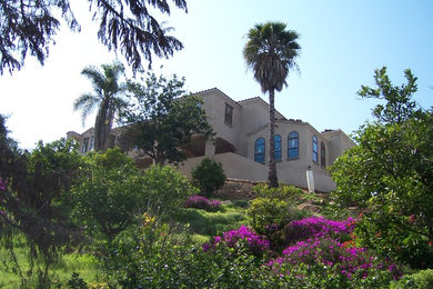 Foto de fachada beige mediterránea grande de tres plantas con revestimiento de estuco