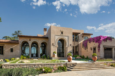 Immagine della villa beige mediterranea a due piani con tetto piano e copertura in tegole