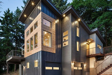 This is an example of a large and gey contemporary house exterior in Portland with metal cladding, three floors and a lean-to roof.