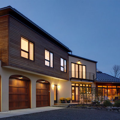Inspiration for a large contemporary beige two-story wood exterior home remodel in New York with a metal roof