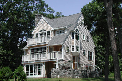 Foto de fachada de casa beige de tres plantas con revestimiento de madera, tejado a dos aguas y tejado de teja de madera