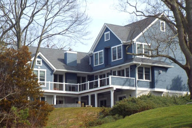 Inspiration for a large timeless blue three-story vinyl exterior home remodel in New York with a shingle roof