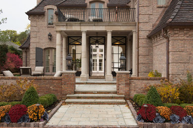 Ispirazione per la villa ampia beige classica a due piani con rivestimento in mattoni, tetto piano e copertura in tegole