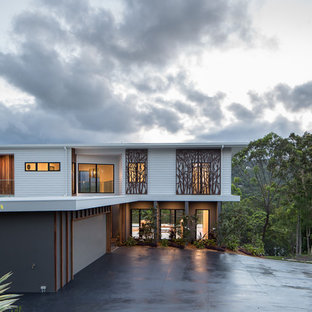 Design ideas for a large contemporary two-storey white house exterior in Gold Coast - Tweed with concrete fiberboard siding, a flat roof and a metal roof.