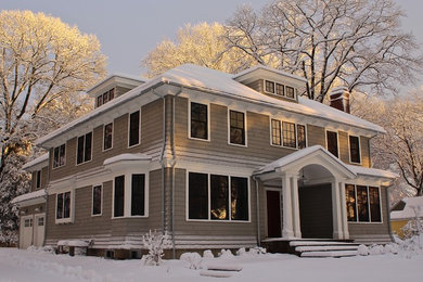 На фото: большой, двухэтажный, деревянный, серый дом в стиле неоклассика (современная классика) с вальмовой крышей с