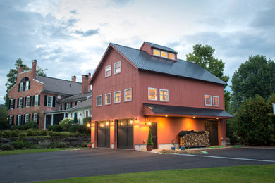 Ejemplo de fachada de casa roja de estilo de casa de campo de tres plantas con revestimiento de madera y tejado de metal