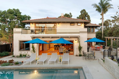 Large beach style beige two-story concrete exterior home photo in San Diego with a shingle roof