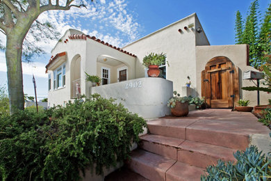 Example of a mid-sized southwest beige two-story stucco exterior home design in San Diego with a tile roof