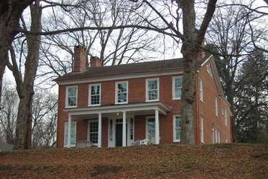 Idée de décoration pour une grande façade de maison rouge vintage en brique à un étage avec un toit à deux pans et un toit en shingle.
