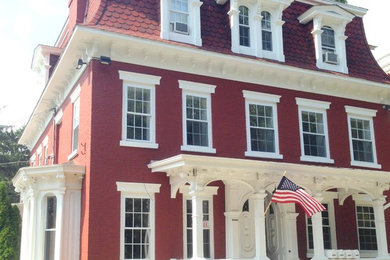 Ejemplo de fachada roja de estilo americano extra grande de tres plantas con revestimiento de ladrillo