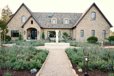 Imagen de fachada de casa multicolor clásica extra grande de dos plantas con revestimiento de piedra, tejado a dos aguas y tejado de teja de barro