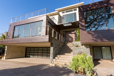 Photo of an expansive and brown contemporary detached house in Los Angeles with three floors, mixed cladding, a flat roof and a mixed material roof.