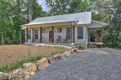 Foto de fachada de casa blanca rústica pequeña de dos plantas con tejado a dos aguas y tejado de metal