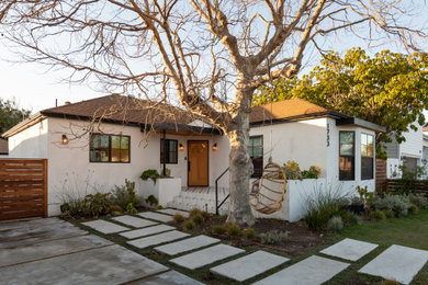 This is an example of a medium sized and white contemporary bungalow render detached house in Los Angeles with a hip roof and a tiled roof.