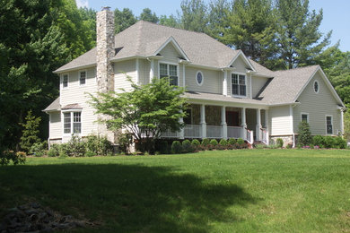 Diseño de fachada de casa beige clásica grande de dos plantas con revestimiento de madera y tejado de teja de madera