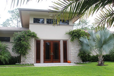Example of a large mountain style beige two-story mixed siding house exterior design in Miami with a clipped gable roof and a tile roof