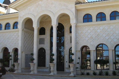 ロサンゼルスにあるラグジュアリーな巨大な地中海スタイルのおしゃれな家の外観 (石材サイディング) の写真