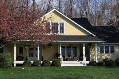 Exemple d'une façade de maison jaune chic en panneau de béton fibré de taille moyenne et de plain-pied avec un toit à deux pans.