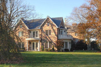 Esempio della facciata di una casa bianca classica a due piani di medie dimensioni con rivestimento in pietra e tetto a capanna