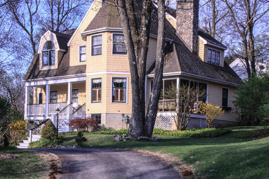 Cette photo montre une façade de maison jaune chic de taille moyenne et à un étage avec un revêtement mixte et un toit à deux pans.