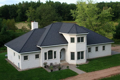 Example of a transitional exterior home design in Other with a hip roof