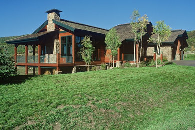 Large elegant brown two-story wood exterior home photo in Denver with a shingle roof