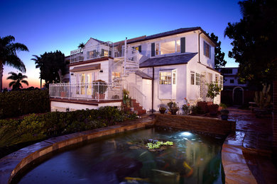 Large beach style white two-story stucco exterior home photo in Los Angeles
