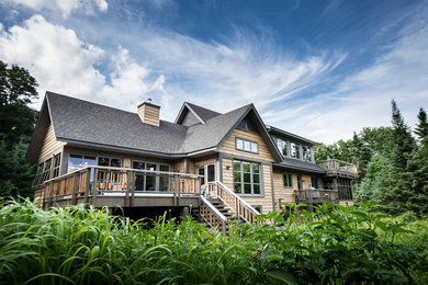 Mountain style brown two-story wood exterior home photo in Montreal with a shingle roof