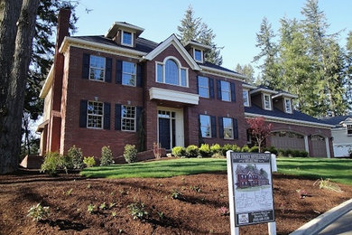 Large elegant brown two-story brick exterior home photo in Portland