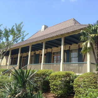 Design ideas for a mid-sized asian one-storey stucco beige house exterior in New Orleans with a hip roof and a shingle roof.