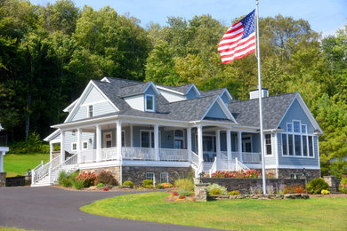 Esempio della villa grigia american style a due piani con rivestimento in legno e copertura a scandole