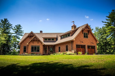 Cette photo montre une grande façade de maison marron en bois à un étage avec un toit à deux pans.