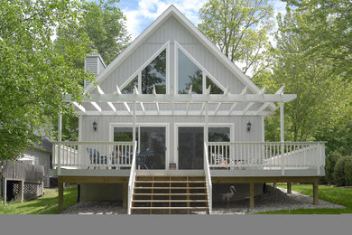 Modelo de fachada de casa gris clásica de tamaño medio de dos plantas con revestimiento de madera, tejado a dos aguas y tejado de teja de madera