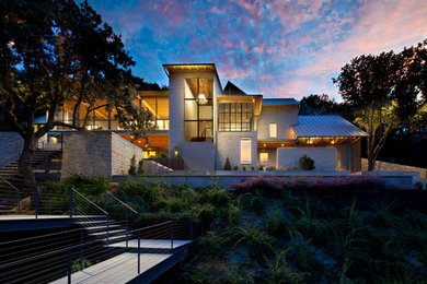 Design ideas for an expansive traditional house exterior in Austin with three floors, metal cladding and a pitched roof.