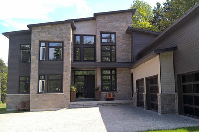 Ejemplo de fachada de casa gris minimalista grande de dos plantas con tejado de teja de madera, revestimientos combinados y tejado plano