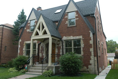 На фото: большой, двухэтажный, красный частный загородный дом в классическом стиле с комбинированной облицовкой, двускатной крышей и крышей из гибкой черепицы с