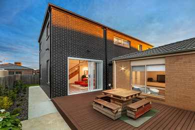 Diseño de fachada de casa gris minimalista de tamaño medio de dos plantas con revestimiento de ladrillo, tejado a dos aguas y tejado de teja de barro