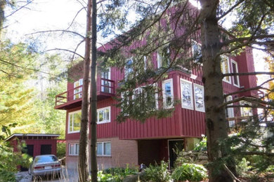 Ejemplo de fachada de casa roja contemporánea de tamaño medio de tres plantas con revestimiento de madera, tejado de un solo tendido y tejado de teja de madera