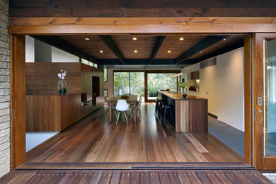 Diseño de fachada de casa beige contemporánea grande de una planta con revestimiento de madera, tejado plano y tejado de metal